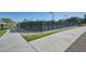 Community tennis courts behind a green fence with a covered seating area and nearby pathways at 21047 N Alma Dr, Maricopa, AZ 85138