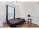 A cozy bedroom featuring hardwood floors, a ceiling fan, and a window with blinds at 34924 N 30Th Ave, Phoenix, AZ 85086