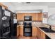 This traditional kitchen offers wood cabinets, granite countertops, black appliances and backsplash at 34924 N 30Th Ave, Phoenix, AZ 85086