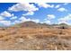 Desert landscape featuring native plants and picturesque hills under a blue sky with scattered white clouds at 34924 N 30Th Ave, Phoenix, AZ 85086