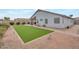 Backyard featuring a covered patio, turf lawn, and decorative rock at 35282 N Shorthorn Trl, San Tan Valley, AZ 85143