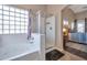 Bathroom featuring a tub, glass block window, shower, and access to the bedroom at 35282 N Shorthorn Trl, San Tan Valley, AZ 85143
