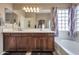 Bright bathroom featuring double sinks, wood cabinets, and a glass block window at 35282 N Shorthorn Trl, San Tan Valley, AZ 85143