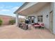 Charming patio with stone flooring, offering an inviting outdoor living space with comfortable seating and a grill at 35282 N Shorthorn Trl, San Tan Valley, AZ 85143