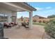 Cozy covered patio with stone flooring and comfortable seating, ideal for outdoor relaxation and entertaining at 35282 N Shorthorn Trl, San Tan Valley, AZ 85143