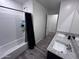 Modern bathroom featuring double granite sinks, tub with tile surround, and wood-look flooring at 3829 N Princeton Ln, Casa Grande, AZ 85122