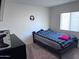 Cozy bedroom with plush carpet, black furniture and a window providing natural light at 3829 N Princeton Ln, Casa Grande, AZ 85122
