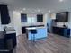 Well-lit kitchen with dark cabinets, a central island, stainless steel appliances, and modern fixtures at 3829 N Princeton Ln, Casa Grande, AZ 85122