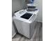 Well-lit laundry room featuring a modern washer and dryer set with gray wood-look flooring at 3829 N Princeton Ln, Casa Grande, AZ 85122