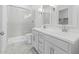 This well-lit bathroom features a shower with glass doors, dual sinks and bright marble-look countertops at 3889 S 233Rd Ln, Buckeye, AZ 85326