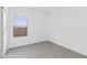 A simple, yet serene bedroom features a window and neutral colored walls and carpet at 3889 S 233Rd Ln, Buckeye, AZ 85326