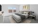 This bedroom features neutral tones, with a queen bed, bedside table, and natural light from the two windows at 3889 S 233Rd Ln, Buckeye, AZ 85326