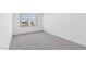 Minimalist bedroom with light gray carpet, white walls, and a large window for natural light at 3889 S 233Rd Ln, Buckeye, AZ 85326