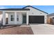 Charming single-story home showcasing a covered porch and a two-car garage at 3889 S 233Rd Ln, Buckeye, AZ 85326