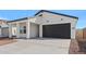 A single story home featuring a black garage door and drought resistant landscaping at 3889 S 233Rd Ln, Buckeye, AZ 85326