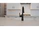 Close-up of the modern kitchen island featuring a sleek black faucet and a quartz countertop with stylish backsplash at 40113 N Alameda Dr, San Tan Valley, AZ 85140