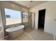 Bright bathroom featuring a modern soaking tub, glass shower, and walk-in closet at 40129 N Alameda Dr, San Tan Valley, AZ 85140