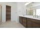 Modern bathroom with dual sinks, walk-in closet, a large mirror and a glass-enclosed shower at 40129 N Alameda Dr, San Tan Valley, AZ 85140