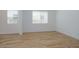 Bright bedroom features wood-look flooring, white walls, and natural light from two windows at 40147 N Alameda Dr, San Tan Valley, AZ 85140