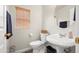 Powder room featuring a white sink, toilet and a round mirror at 4261 E Baylor Ln, Gilbert, AZ 85296