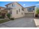 Beige two story home features a driveway leading to a two-car garage with well maintained landscaping at 4261 E Baylor Ln, Gilbert, AZ 85296