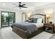 This primary bedroom features a sliding door and a stylish ceiling fan, complete with bedside tables at 4625 E Mountain View Rd, Phoenix, AZ 85028