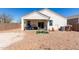 View of the home's backyard and patio, featuring gravel landscaping, block wall, and covered seating area at 5101 E Sharbel Rd, San Tan Valley, AZ 85143