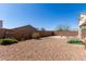 Fenced backyard showing low maintenance landscaping, block wall fence, with a partially covered patio at 5101 E Sharbel Rd, San Tan Valley, AZ 85143