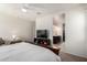 Bright bedroom featuring a large TV, access to the bathroom, and a comfortable chair at 5101 E Sharbel Rd, San Tan Valley, AZ 85143