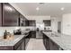 Spacious kitchen with granite counters, stainless appliances, and dark cabinetry at 5101 E Sharbel Rd, San Tan Valley, AZ 85143