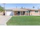 Charming home featuring a well-manicured lawn, brick facade, and a covered front porch at 7430 E Coronado Rd, Scottsdale, AZ 85257