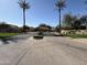 Welcoming community entrance with palm trees, manicured landscaping, and a wide driveway at 7575 E Indian Bend Rd # 1089, Scottsdale, AZ 85250