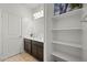 Bathroom with dark wood vanity, white countertop and shelves for ample storage space at 7749 W Florence Ave, Phoenix, AZ 85043