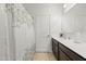 Bathroom with a shower, white patterned shower curtain, and dark wood vanity with white countertops at 7749 W Florence Ave, Phoenix, AZ 85043