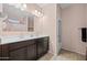 Elegant bathroom boasts a double sink vanity, large mirror, and tiled floors for a spa-like experience at 7749 W Florence Ave, Phoenix, AZ 85043