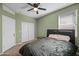 Well-lit bedroom featuring neutral walls, a dark wood bed frame, closet and ceiling fan at 7749 W Florence Ave, Phoenix, AZ 85043