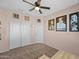 Charming bedroom featuring a ceiling fan, neutral walls, and closet for ample storage space at 7749 W Florence Ave, Phoenix, AZ 85043