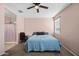 Comfortable bedroom featuring a ceiling fan, neutral walls, and convenient access to an adjacent bathroom at 7749 W Florence Ave, Phoenix, AZ 85043