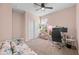 Versatile bedroom with home office setup, accented by natural light and a ceiling fan, offers flexible space at 7749 W Florence Ave, Phoenix, AZ 85043
