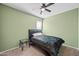 Well-lit bedroom featuring neutral walls, a dark wood bed frame and ceiling fan at 7749 W Florence Ave, Phoenix, AZ 85043