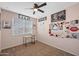 Well-lit bedroom with a ceiling fan, featuring modern decor and a cozy atmosphere, ideal for relaxation at 7749 W Florence Ave, Phoenix, AZ 85043