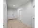 Bright hallway with tile floors, white walls, and doorways leading to various rooms in the home at 7749 W Florence Ave, Phoenix, AZ 85043