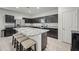 Open concept kitchen with dark cabinetry, stainless steel appliances, and a large island with granite countertop at 7749 W Florence Ave, Phoenix, AZ 85043