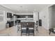 Open-concept kitchen and dining area with stainless steel appliances, dark cabinets, and tile flooring at 7749 W Florence Ave, Phoenix, AZ 85043