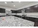 Gourmet kitchen with granite countertops, dark cabinetry, stainless steel appliances, and recessed lighting at 7749 W Florence Ave, Phoenix, AZ 85043