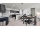 Open-concept kitchen and dining area with stainless steel appliances, a kitchen island, and seating at 7749 W Florence Ave, Phoenix, AZ 85043