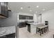 Open-concept kitchen featuring dark wood cabinets, stainless steel appliances, and a large granite island with bar seating at 7749 W Florence Ave, Phoenix, AZ 85043