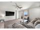 Spacious living room with plush sofa, sliding glass door access to the backyard, and ceiling fan at 7749 W Florence Ave, Phoenix, AZ 85043