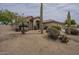 Landscaped front yard with desert foliage and a well-maintained lawn at 9142 E La Posada Ct, Scottsdale, AZ 85255