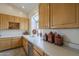 Well-lit kitchen showcasing wood cabinetry, white countertops, and a stainless steel dishwasher at 9142 E La Posada Ct, Scottsdale, AZ 85255